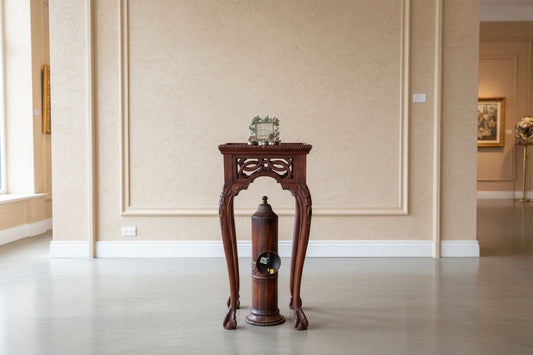 Wooden pepper grinder and mill on a table with decorative items in the background