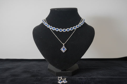 Jewelry set with necklace and earrings on a black velvet stand.