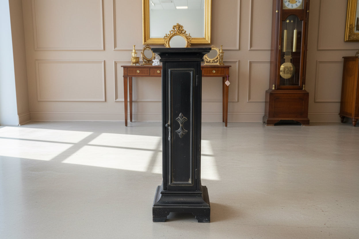 Black wooden cabinet with glass doors in a room with a concrete floor.