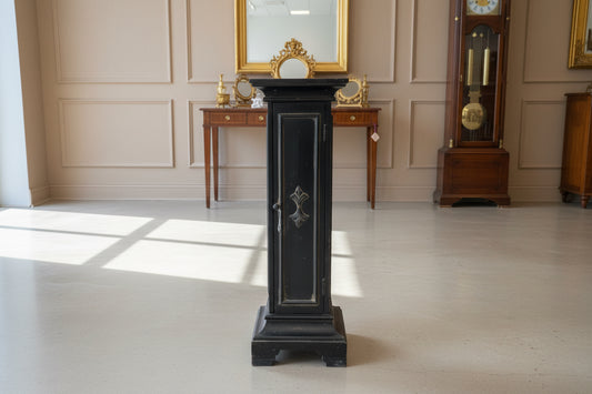 Black wooden cabinet with glass doors in a room with a concrete floor.